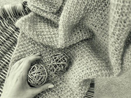 Handmaid plaid on the chair with the two wooden balls woman's hand holding one of them black and...