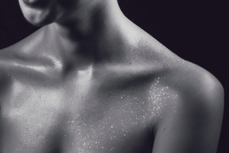 Facial expression and brilliant smile of girl with bright evening make-up, shiny glamor glow cosmetics. The creative makeup of the girl is covered with sparkles dark backgroundの写真素材