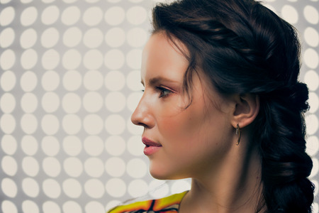 Beautiful brunette in the background of the subway at night looking at reflection
