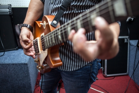 Man playing guitar in rehearsal roomの写真素材