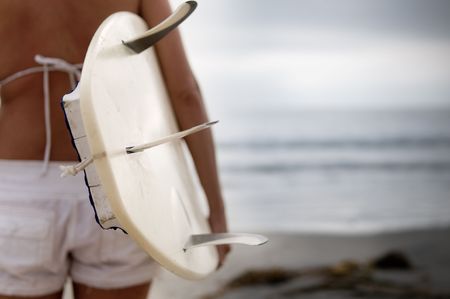 A woman surfer looking out at the ocean wavesの写真素材