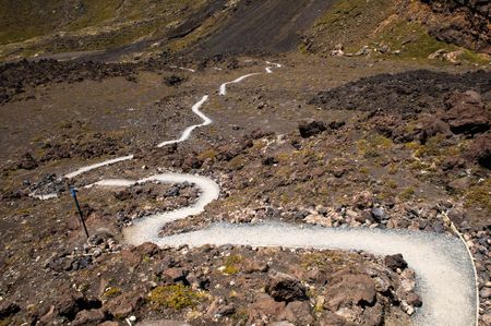 A steep path curving through alpine tundra