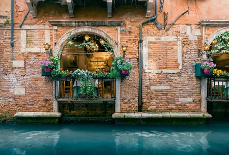 Traditional Italian Restaurant along Scenic Venetian Canal in Venice, Italyの写真素材