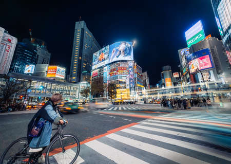 Tokyo - 27 March 2019 - Electrifying Shibuya Crossing at Night with Neon Signs and Night Life and Moving Traffic, Tokyo, Japanのeditorial素材