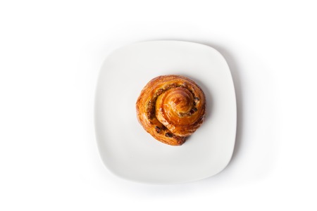 Freshly baked sweet roll on a white plateの写真素材