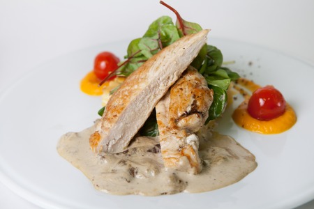 Fried chicken meat with potato garnish and mushroomsの写真素材