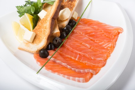 Fresh pink smoked and sliced salmon with croutonsの写真素材