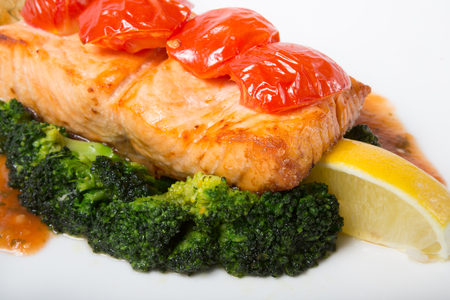 Salmon steak served with broccoli and lemonの写真素材
