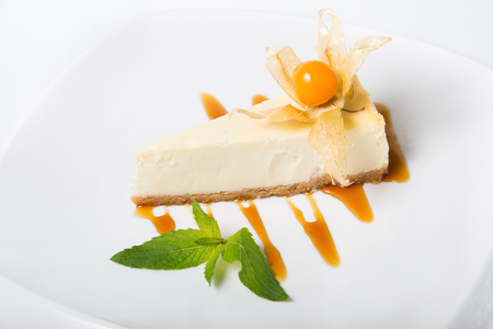 Cheese cake on a plate served with yellow physalisの写真素材