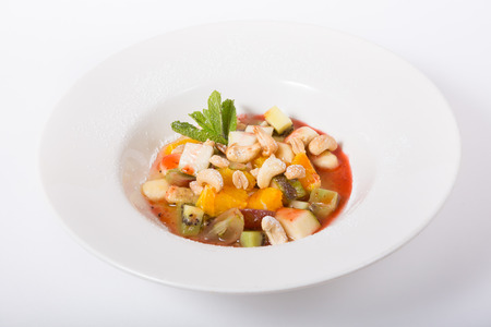 Mixed fruit salad served in white plateの写真素材