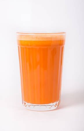 Fresh carrot juice glass in a white backgroundの写真素材