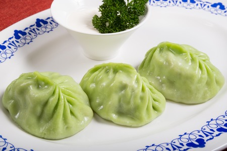 Spinach momo with sour sauce on a white plateの写真素材