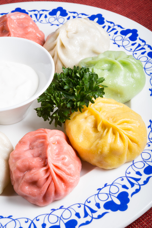 Momos in different colours served with sour creamの写真素材