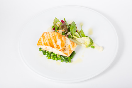 Fried white fish fillet with peas garnish