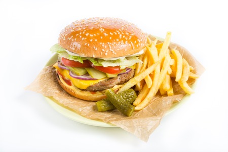 Hamburger with french fries and pickles on wrapping paper