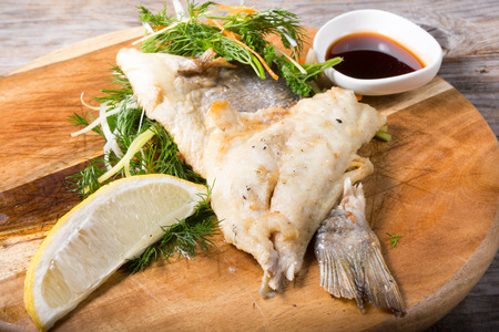 Fried dorado fish served with herbs and soy sauce