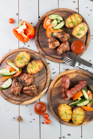 Set of grilled meat served with vegetablesの写真素材