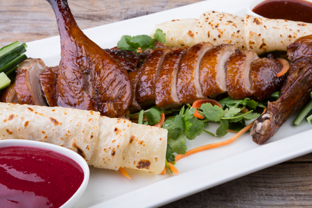 Traditional chinese peking duck dish served on wooden tableの写真素材
