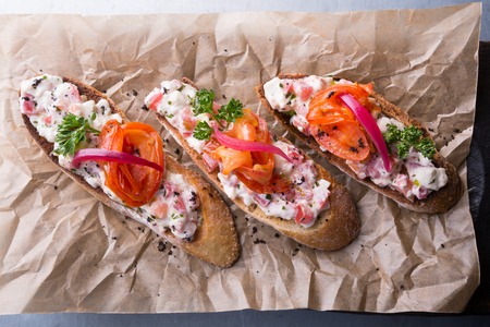 Bruschetta italian snack sandwiches with salad on wooden boardの写真素材