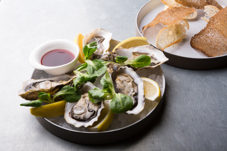 Oysters platter with lemon served with croutonsの写真素材