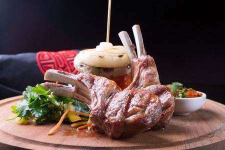 Grilled lamb meat served with vegetables and sauce