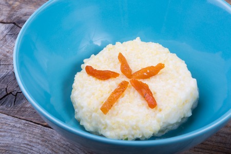 Millet porridge served with dried apricot in bowlの写真素材