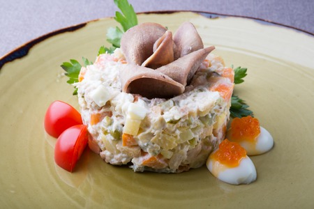 Russian olivier salad served with ham and red caviarの写真素材