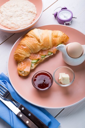 Oatmeal porridge served with croissant and boiled eggの写真素材