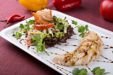 Cooked chicken meat served with shrimp and lettuce saladの写真素材