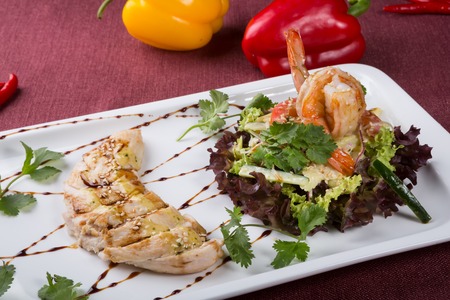 Cooked chicken meat served with shrimp and lettuce saladの写真素材