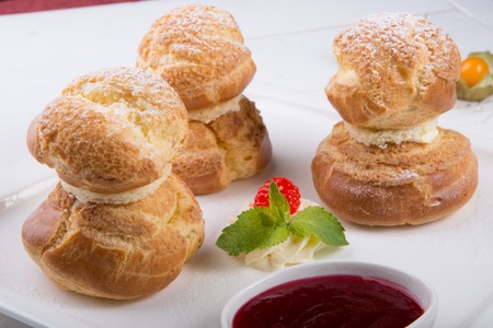 Baked french desserts suffed with cream and served with jam