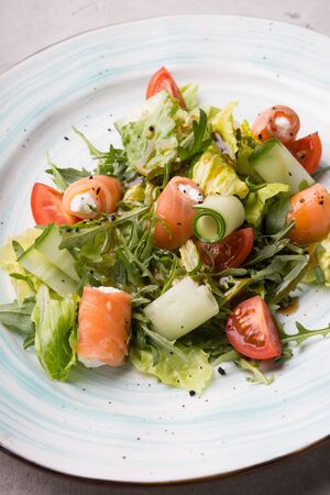 Salmon and white cheese mixed vegetable salad served with arugulaの写真素材