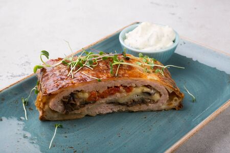 Slice of meat roll cake served with sour creamの写真素材