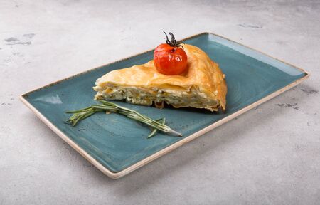 Slice of traditional cheese and herb pie served on a plateの写真素材