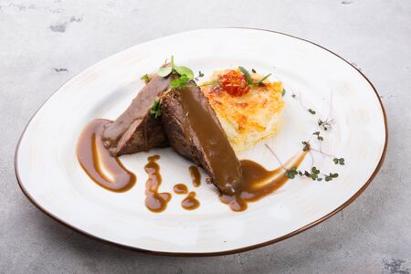 Steamed beef meat served with baked potato garnishの写真素材