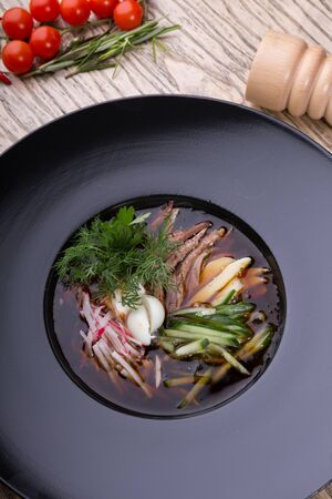 Traditional russian summer cold soup okroshka in a black bowlの写真素材