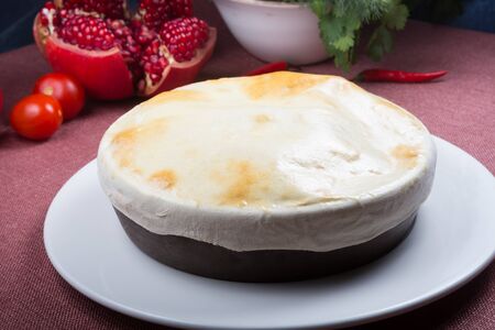 Rustic soup pot covered with baked bread