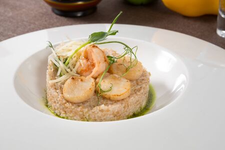 Scallops and shrimps served with brown riceの写真素材