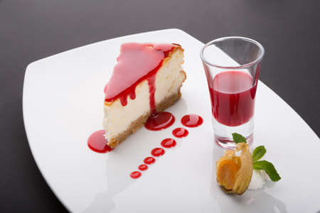 Piece of cheesecake with red cranberries sauceの写真素材