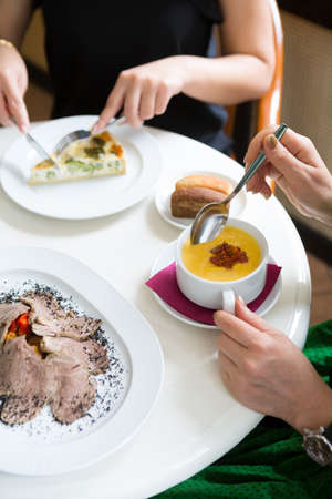 Two women having lunch in a cafeの写真素材