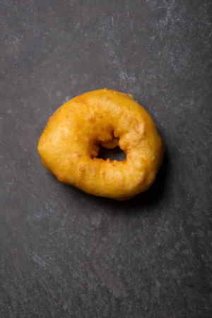 Freshly baked donut on black concrete background