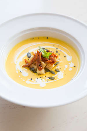 Whole baked neapolitan pepperoni pizza on white cafe tableの写真素材