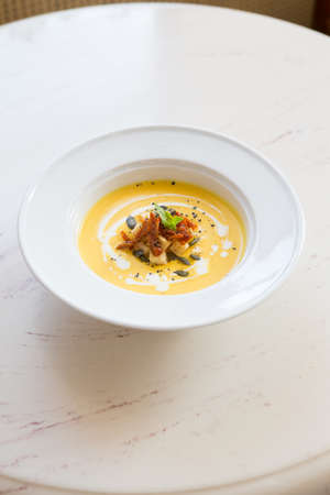 Round neapolitan pizza with ham and mushrooms on a cafe tableの写真素材