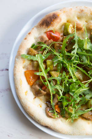 Whole neapolitan seafood pizza served on a marble cafe tableの写真素材