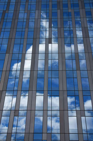 Modern skyscraper with sky and white clouds reflections