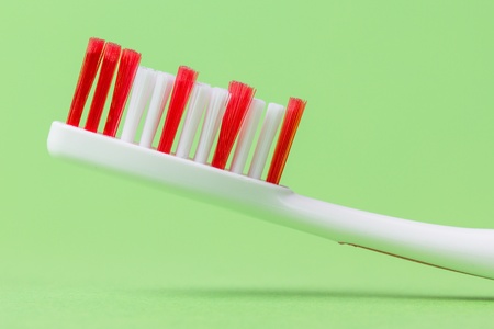 A pink toothbrush on a green backgroundの写真素材