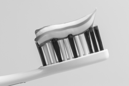 A toothbrush with toothpaste in black and whiteの写真素材
