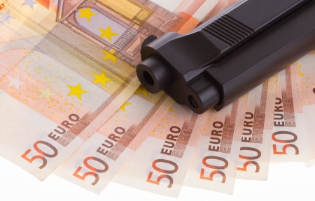 A gun on top of some 50 euro banknotesの写真素材