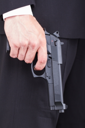 Man with gun, business suit, focus on the gunの写真素材