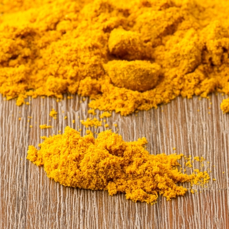 Heap of turmeric on isolated wood backgroundの写真素材